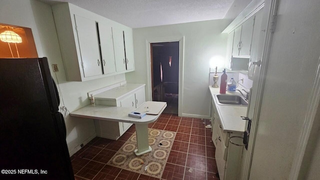 2652 Townsend Blvd, Jacksonville, FL 32211 - kitchen featuring light countertops, freestanding refrigerator, a textured ceiling, white cabinets, and a sink