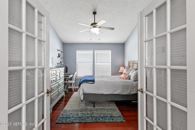bedroom with french doors, dark wood finished floors, and a textured ceiling