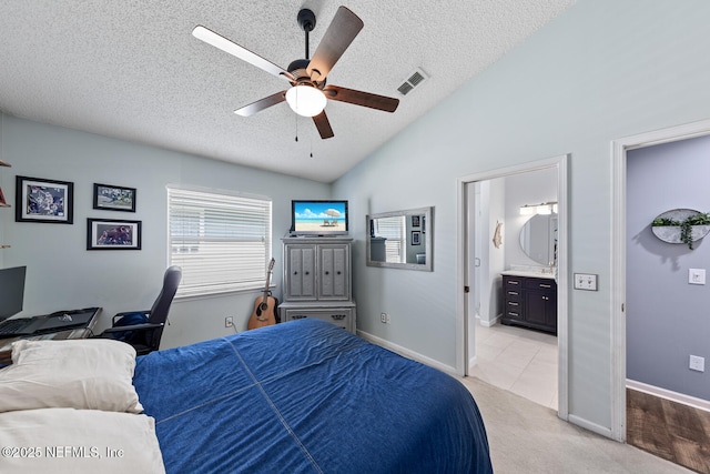 bedroom with visible vents, a textured ceiling, connected bathroom, vaulted ceiling, and light colored carpet