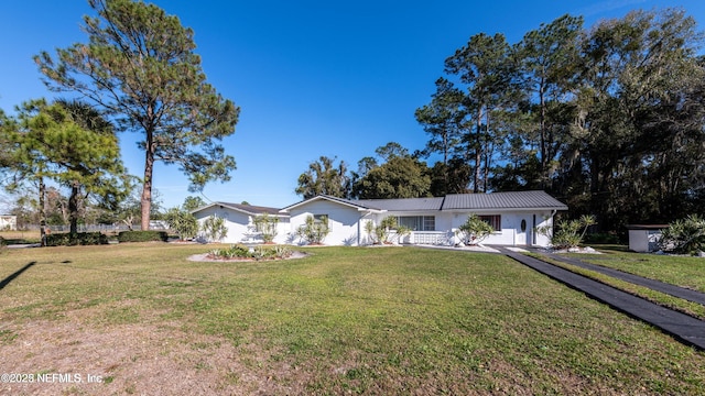 single story home with a front lawn, metal roof, and stucco siding