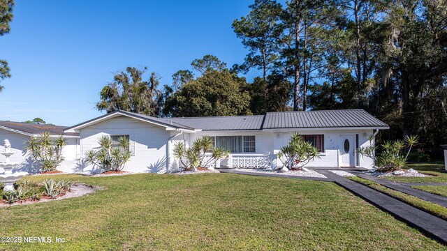 single story home with metal roof and a front lawn