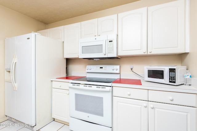 kitchen with light countertops, white cabinetry, a textured ceiling, light tile patterned floors, and white appliances