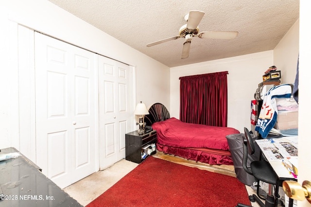 carpeted bedroom featuring a closet, a textured ceiling, and ceiling fan