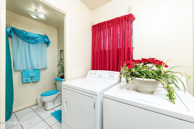 washroom with independent washer and dryer, a textured ceiling, laundry area, and light tile patterned floors