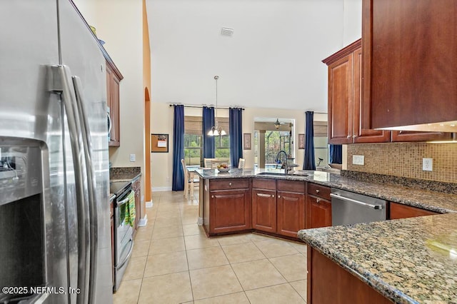 420 Chattan Way, Saint Johns, FL 32259 - kitchen featuring tasteful backsplash, light tile patterned floors, a sink, appliances with stainless steel finishes, and a peninsula
