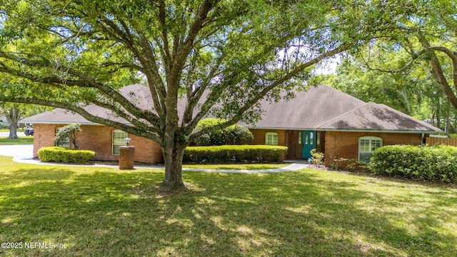 view of front of home with a front yard and brick siding