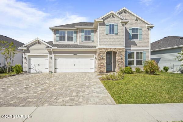 73 Lily Landing Dr, Saint Augustine, FL 32092 - craftsman inspired home featuring a front yard, decorative driveway, and stone siding
