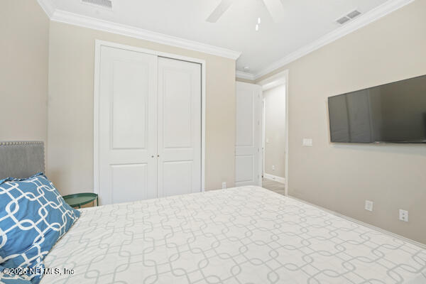 73 Lily Landing Dr, Saint Augustine, FL 32092 - bedroom featuring a ceiling fan, crown molding, a closet, and visible vents