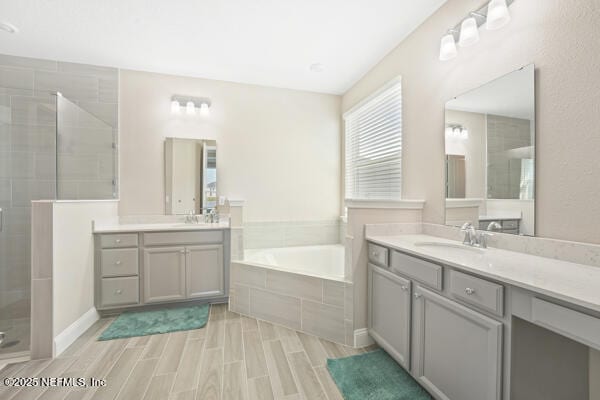 73 Lily Landing Dr, Saint Augustine, FL 32092 - bathroom featuring a sink, two vanities, a shower stall, a garden tub, and wood finish floors