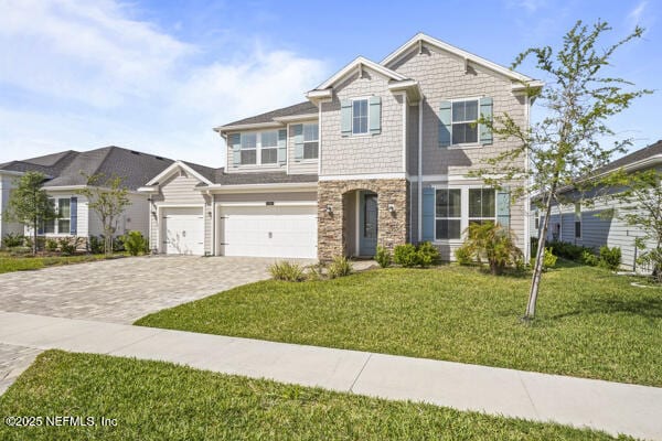 73 Lily Landing Dr, Saint Augustine, FL 32092 - craftsman house with a front yard, decorative driveway, stone siding, and a garage