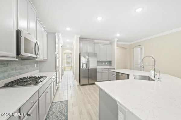 73 Lily Landing Dr, Saint Augustine, FL 32092 - kitchen with crown molding, decorative backsplash, a sink, light wood-style flooring, and appliances with stainless steel finishes