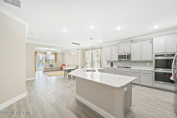 73 Lily Landing Dr, Saint Augustine, FL 32092 - kitchen featuring light countertops, stainless steel appliances, a sink, an island with sink, and visible vents