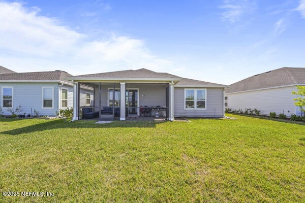 73 Lily Landing Dr, Saint Augustine, FL 32092 - back of property with a lawn and a sunroom