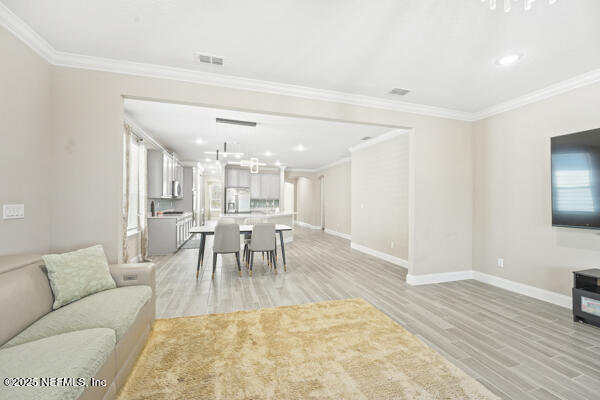 73 Lily Landing Dr, Saint Augustine, FL 32092 - living area with baseboards, ornamental molding, visible vents, and light wood-style floors
