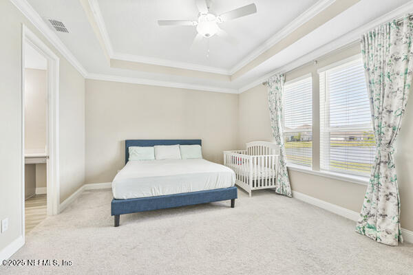 73 Lily Landing Dr, Saint Augustine, FL 32092 - carpeted bedroom featuring ornamental molding, a tray ceiling, baseboards, and visible vents