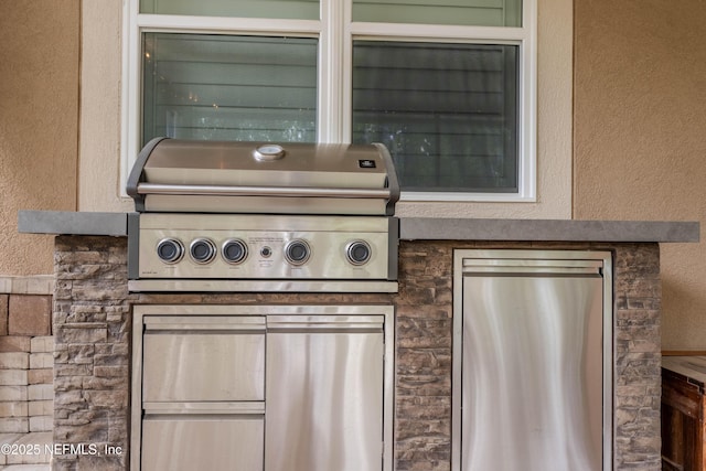 exterior details with refrigerator, stone siding, and stucco siding