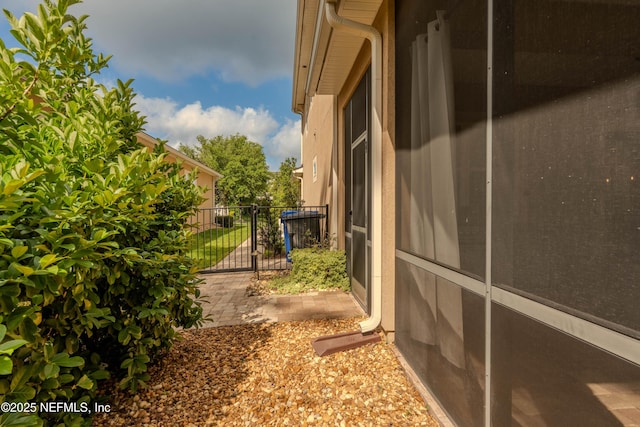 view of side of home with fence and a gate