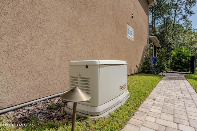 details featuring stucco siding and a power unit