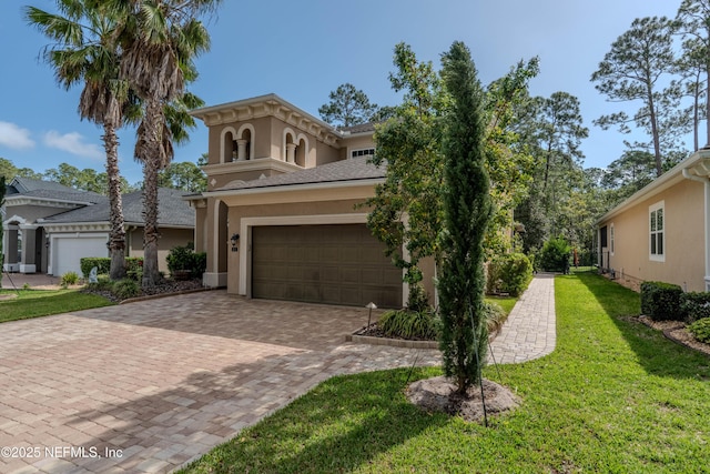 view of front of house with decorative driveway, a garage, a front lawn, and stucco siding