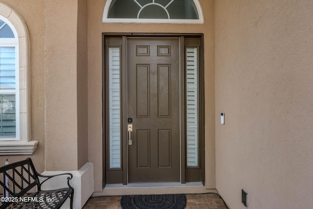 entrance to property featuring stucco siding
