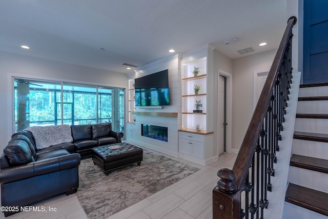 living room with visible vents, stairs, baseboards, recessed lighting, and a large fireplace