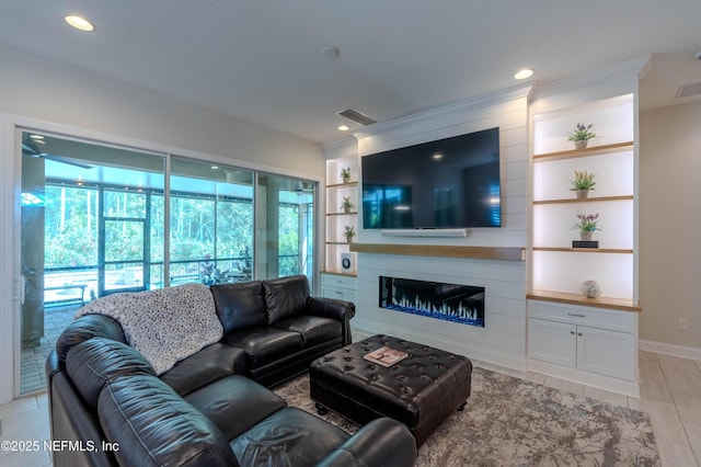 living area with a fireplace, recessed lighting, built in shelves, and visible vents