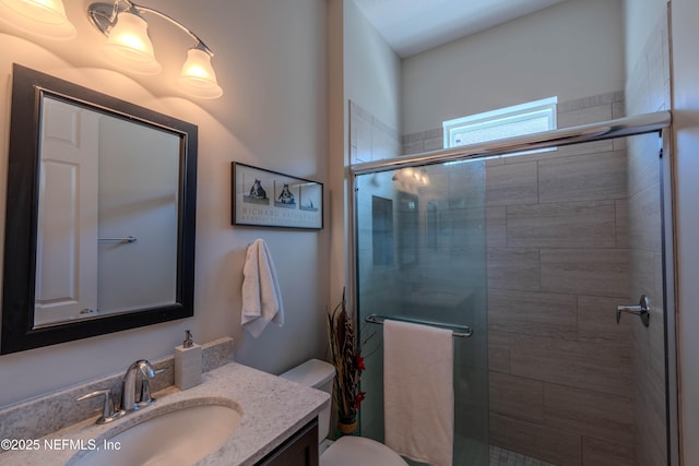 full bath featuring vanity, a stall shower, and toilet