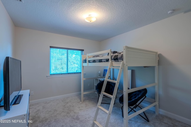 bedroom featuring a textured ceiling, baseboards, and carpet