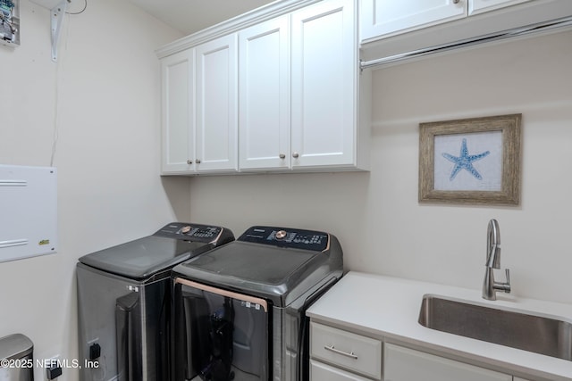laundry area featuring a sink, cabinet space, and washer and dryer