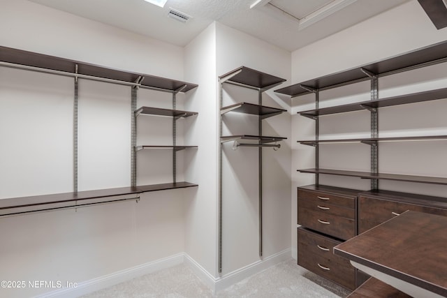 walk in closet featuring light colored carpet and visible vents