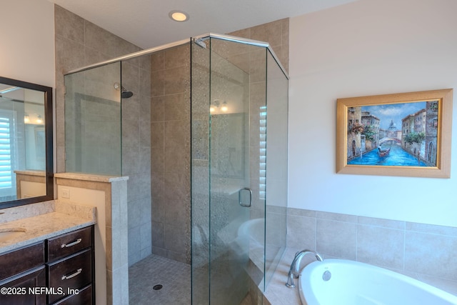bathroom featuring vanity, a stall shower, and a garden tub