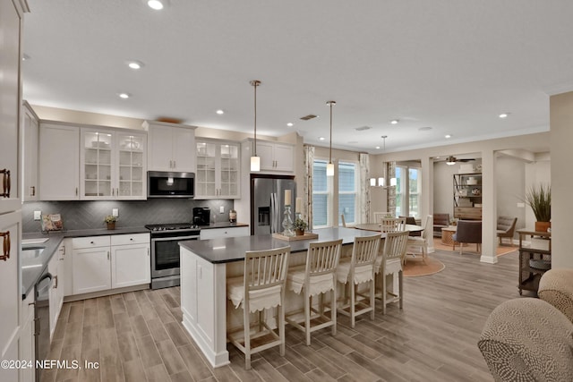 75 Mallow Ct, Saint Johns, FL 32259 - kitchen featuring a kitchen island, appliances with stainless steel finishes, decorative backsplash, and light wood-style floors