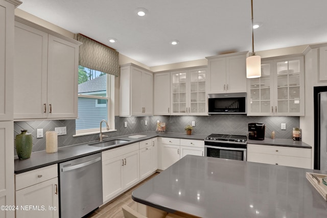75 Mallow Ct, Saint Johns, FL 32259 - kitchen featuring dark countertops, appliances with stainless steel finishes, a sink, tasteful backsplash, and glass insert cabinets