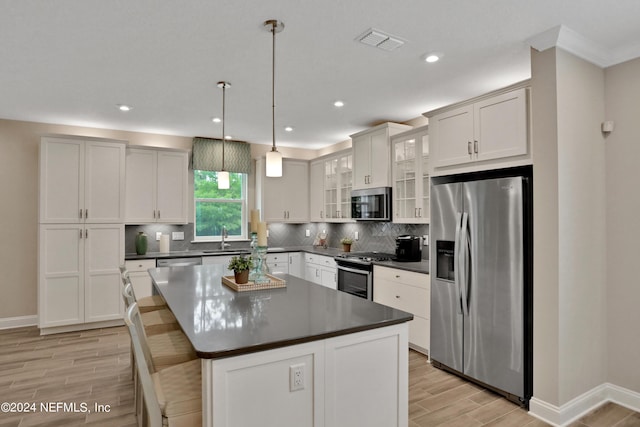 75 Mallow Ct, Saint Johns, FL 32259 - kitchen with visible vents, dark countertops, a sink, light wood-style flooring, and stainless steel appliances