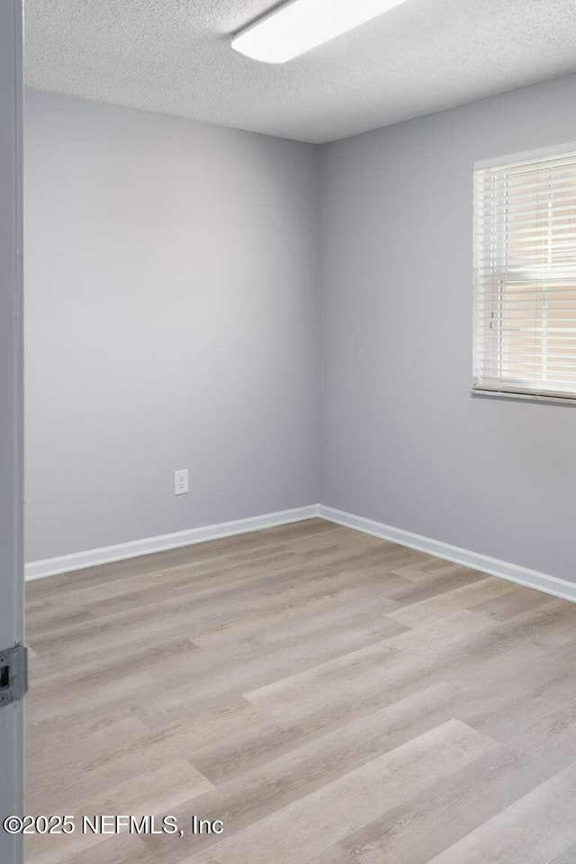 601 Robert Livingston St, Orange Park, FL 32073 - spare room featuring baseboards, wood finished floors, and a textured ceiling