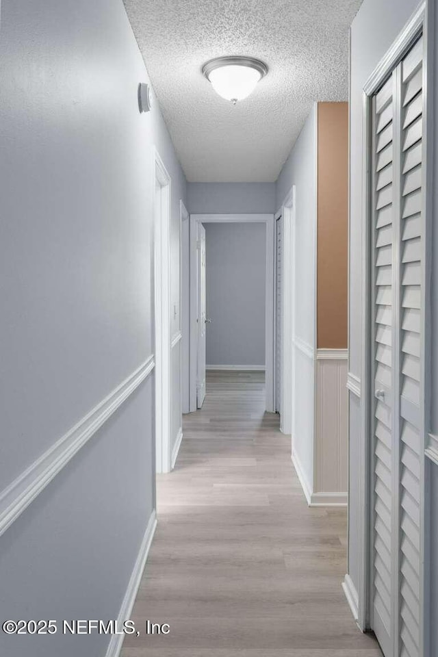 601 Robert Livingston St, Orange Park, FL 32073 - hall with light wood-type flooring, a textured ceiling, and baseboards