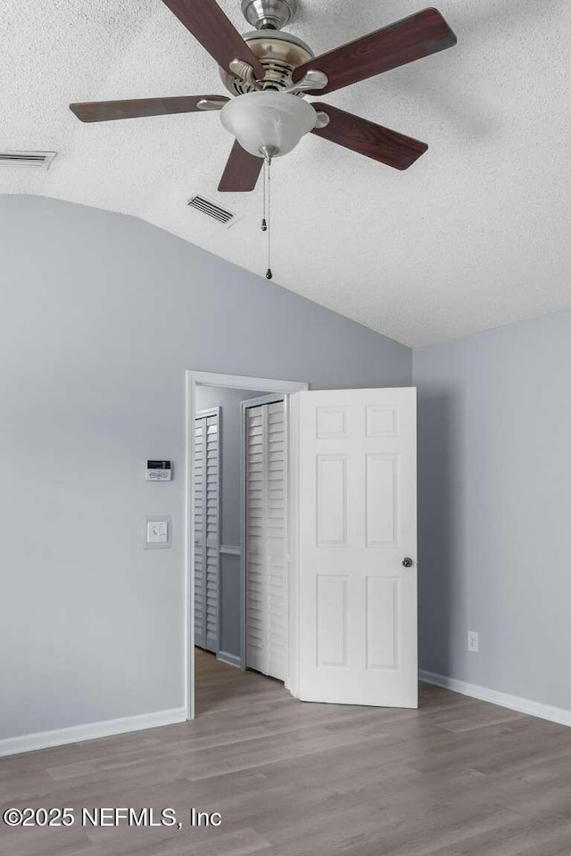 601 Robert Livingston St, Orange Park, FL 32073 - unfurnished bedroom featuring a textured ceiling, a closet, visible vents, wood finished floors, and lofted ceiling