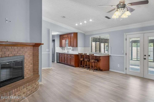 601 Robert Livingston St, Orange Park, FL 32073 - kitchen with ornamental molding, visible vents, brown cabinets, a sink, and french doors
