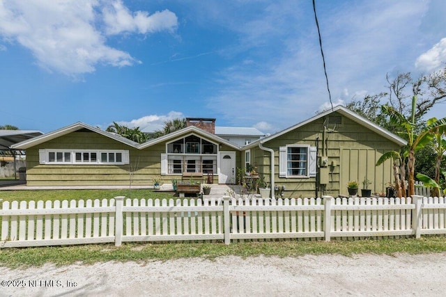 6960 Charles St, Saint Augustine, FL 32080 - view of front of house with a chimney and a fenced front yard