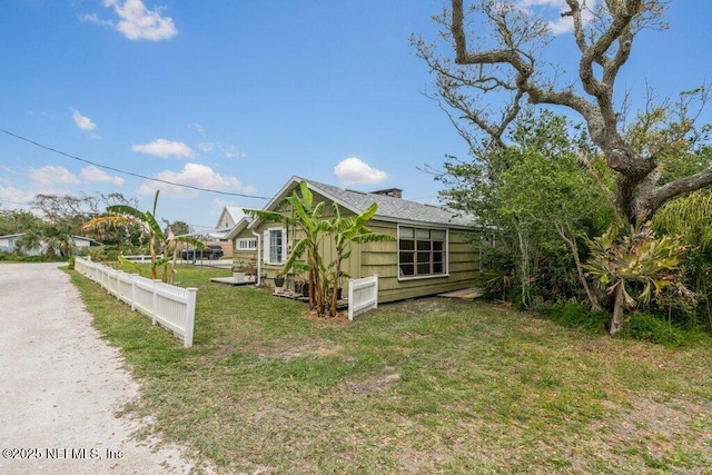 6960 Charles St, Saint Augustine, FL 32080 - view of home's exterior with dirt driveway, fence, a lawn, and a chimney