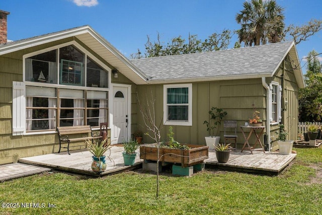 6960 Charles St, Saint Augustine, FL 32080 - back of property featuring a chimney, a shingled roof, and a lawn