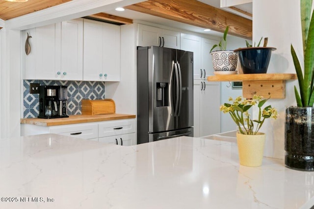 6960 Charles St, Saint Augustine, FL 32080 - kitchen featuring tasteful backsplash, open shelves, stainless steel fridge, white cabinetry, and light stone countertops