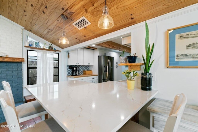 6960 Charles St, Saint Augustine, FL 32080 - kitchen with stainless steel fridge, a peninsula, visible vents, a kitchen bar, and wooden ceiling