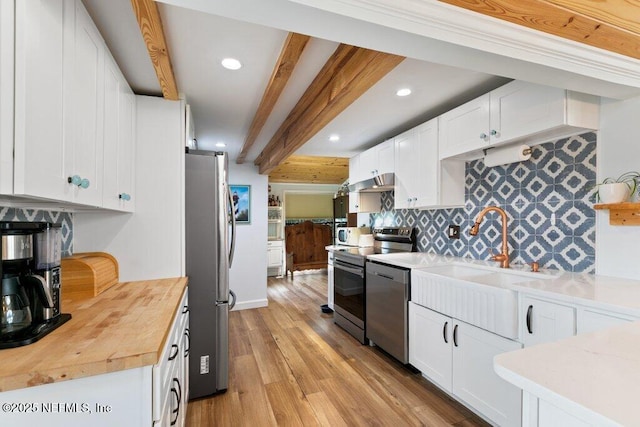 6960 Charles St, Saint Augustine, FL 32080 - kitchen featuring under cabinet range hood, light wood-style floors, beamed ceiling, stainless steel appliances, and a sink