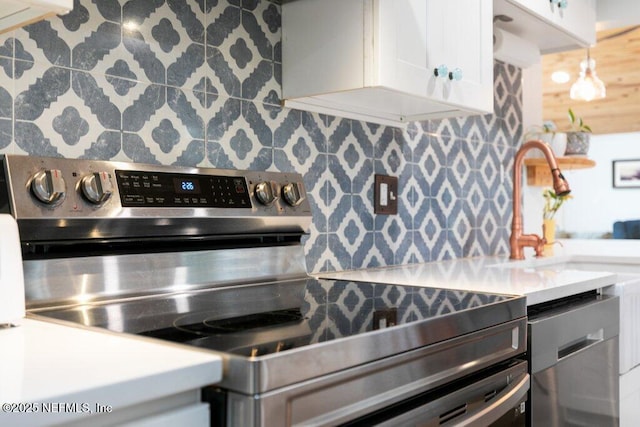6960 Charles St, Saint Augustine, FL 32080 - kitchen with tasteful backsplash, light countertops, white cabinets, and appliances with stainless steel finishes