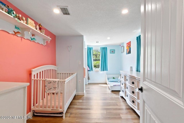 6960 Charles St, Saint Augustine, FL 32080 - bedroom with baseboards, recessed lighting, light wood-style flooring, a textured ceiling, and visible vents