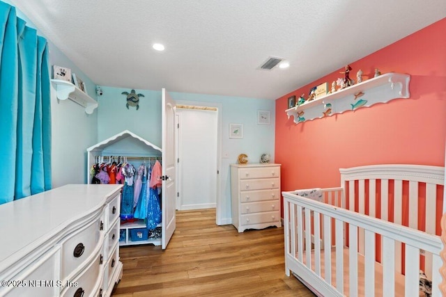 6960 Charles St, Saint Augustine, FL 32080 - bedroom featuring visible vents, light wood-style flooring, and a textured ceiling