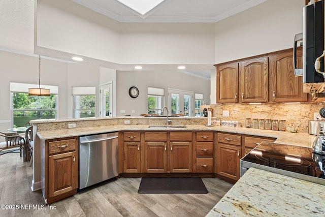 kitchen with a sink, ornamental molding, plenty of natural light, and stainless steel appliances