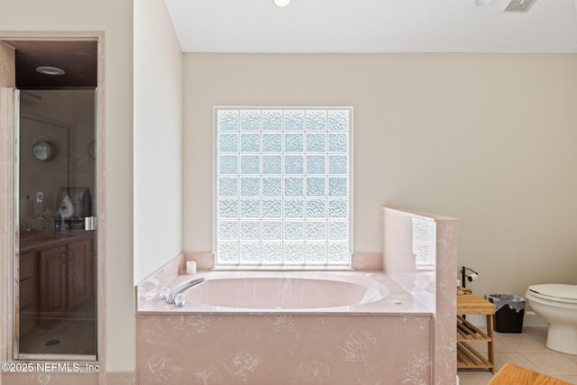 bathroom featuring tile patterned floors, plenty of natural light, and a garden tub