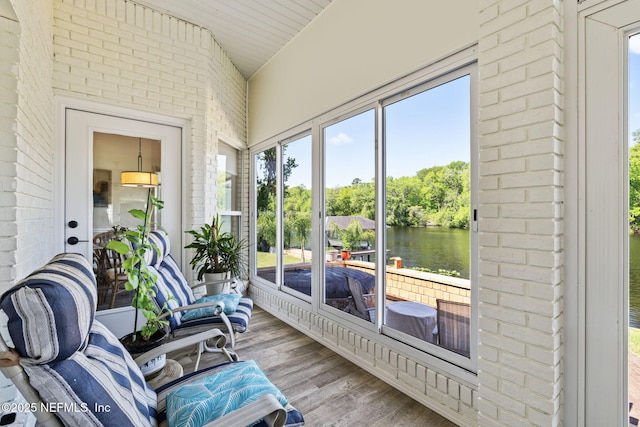 sunroom / solarium featuring a water view and plenty of natural light